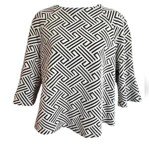 May include: A black and white geometric patterned sweater with three-quarter sleeves. The pattern consists of intersecting lines creating a maze-like design. The sweater has a round neckline and a slightly flared hem.
