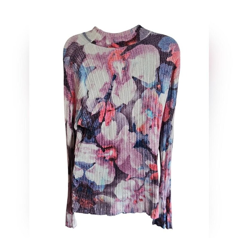 Puede incluir: Una blusa de manga larga y cuello alto con un estampado floral en tonos rosa, morado, azul y blanco. La tela tiene una textura acanalada. La blusa es una prenda de vestir para mujer.