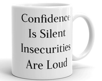 May include: White ceramic coffee mug with black text that reads "Confidence Is Silent Insecurities Are Loud".