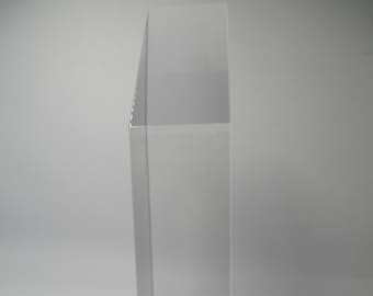 May include: A clear acrylic display case with a black and gold sticker on the bottom.