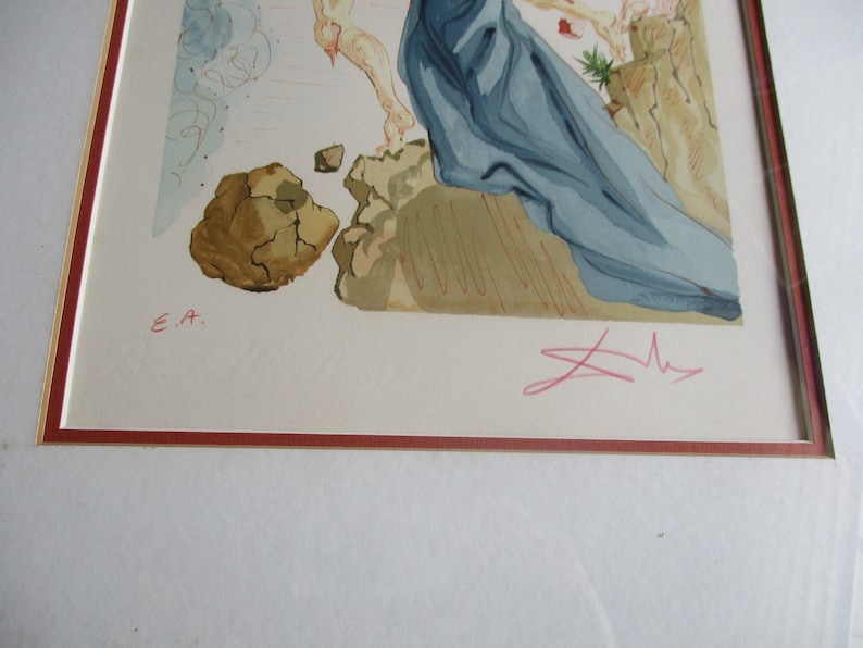 Pu&ograve; includere: Una stampa incorniciata di un dipinto con una figura blu e bianca in primo piano. La figura &egrave; in piedi su una superficie rocciosa. Lo sfondo &egrave; un cielo azzurro e bianco chiaro. La stampa &egrave; firmata "E.A." e "Dali" nell'angolo in basso a destra.