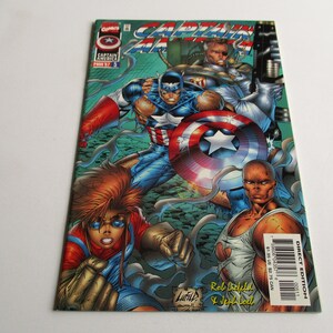 May include: Captain America comic book cover featuring Captain America, a woman with red hair, and a bald man. The cover is illustrated in a comic book style with a green, blue, and red color scheme. The comic book is titled "Captain America" and the issue number is #375.