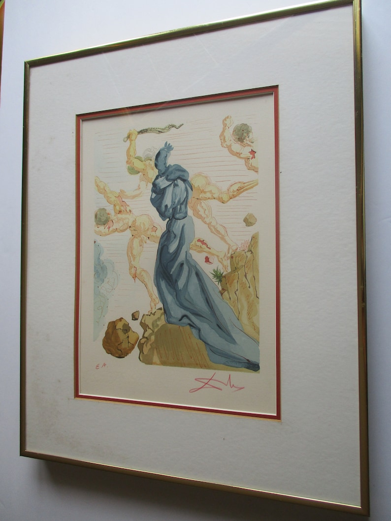 Pu&ograve; includere: Una stampa incorniciata di un dipinto surrealista che raffigura una figura in una veste blu in piedi su una scogliera con altre figure sullo sfondo. La stampa &egrave; firmata "Dal&iacute;" in basso a destra e include le iniziali "E.A." in basso a sinistra.