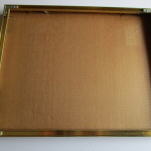 Pu&ograve; includere: Una cornice dorata con un retro in cartone marrone.