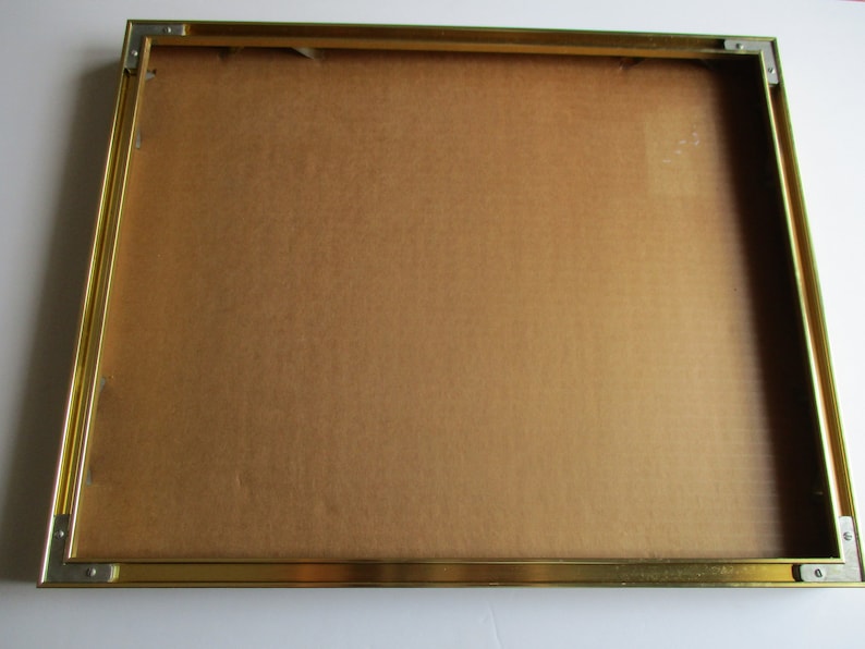 Pu&ograve; includere: Una cornice dorata con un retro in cartone marrone.