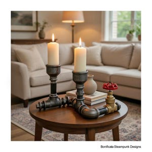 May include: Two lit cream candles in industrial candle holders made from black and grey metal pipes. A red valve and a small vase are on the wooden table. The candle holders have a steampunk design, with a vintage aesthetic.