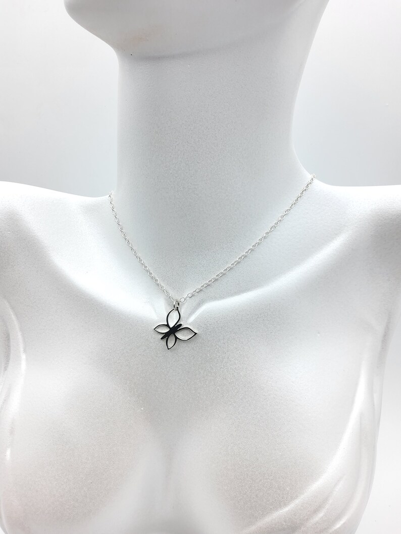 May include: A silver chain necklace with a delicate butterfly pendant. The butterfly is made of a single piece of metal and has a simple, elegant design.