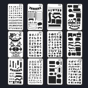 May include: A collection of 12 black plastic stencils for crafts and journaling, featuring diverse designs. Includes letters, numbers, social media icons, banners, speech bubbles, and holiday-themed images. The stencils are arranged in a grid.