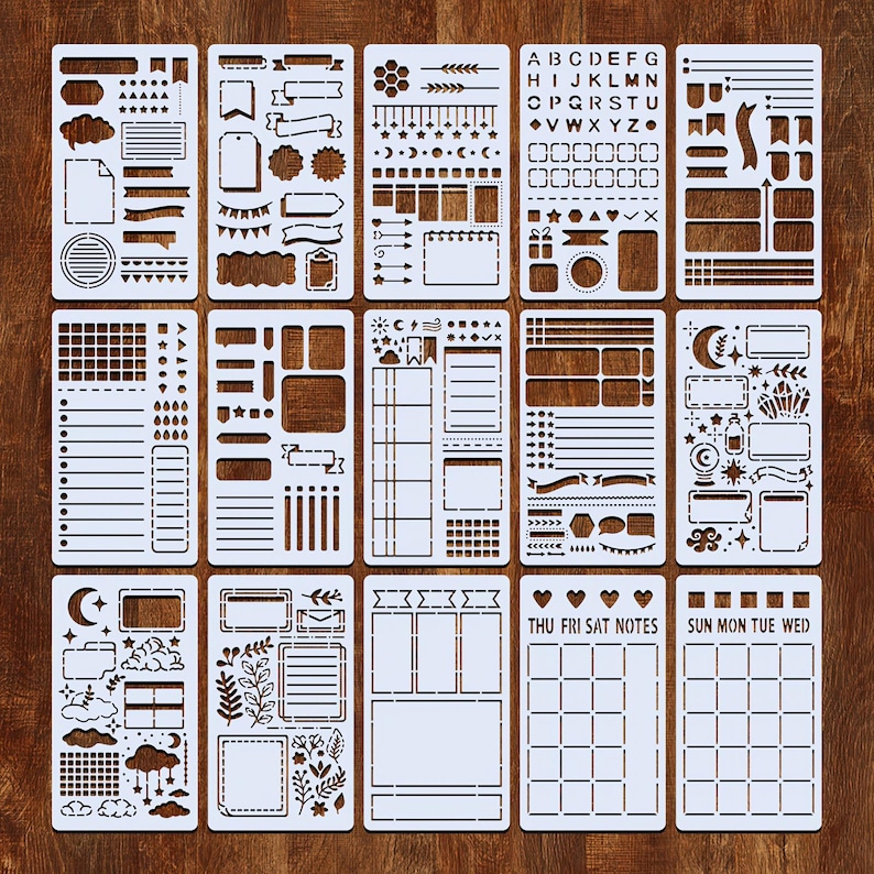 Puede incluir: Un conjunto de plantillas de pl&aacute;stico blanco con varios dise&ntilde;os para bullet journaling y manualidades. Las plantillas incluyen formas, pancartas, calendarios y alfabetos. Las plantillas est&aacute;n dispuestas sobre una superficie de madera marr&oacute;n.