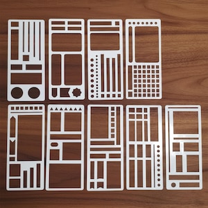 Op de afbeelding: Een verzameling van tien witte plastic sjablonen met diverse geometrische vormen en patronen. Elk sjabloon is rechthoekig met uitgesneden ontwerpen, waaronder lijnen, stippen, vakken en decoratieve elementen. Ideaal voor bullet journaling of knutselen.