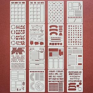 Könnte beinhalten: Ein Set weißer Kunststoffschablonen für Bullet Journaling und Planung. Die Schablonen umfassen Kalender, Banner, florale Designs und ein vollständiges Alphabet. Die Schablonen sind auf rotem Hintergrund angeordnet.
