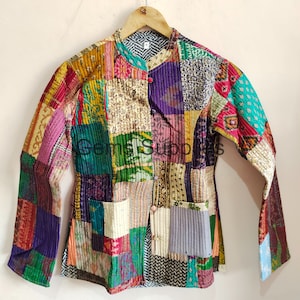 Könnte beinhalten: Eine bunte Patchworkjacke mit Stehkragen und langen Ärmeln. Die Jacke ist aus gestepptem Stoff und hat einen Knopfverschluss.