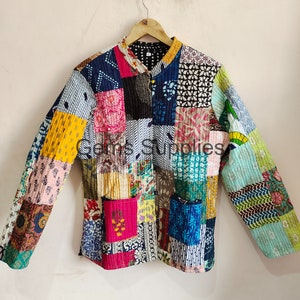Puede incluir: Una chaqueta acolchada de patchwork colorida con cuello mandarín y mangas largas. La chaqueta está hecha de varias telas con estampados florales y geométricos en tonos azules, rosas, amarillos, verdes y marrones.