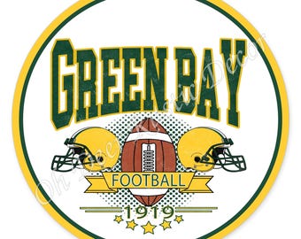 Op de afbeelding: Een ronde afbeelding met de tekst GREEN BAY in donkergroen, twee gele footballhelmen, een bruine football en een gele banner met het woord FOOTBALL. Daaronder staan het jaartal 1919 en vijf gele sterren op een witte achtergrond.