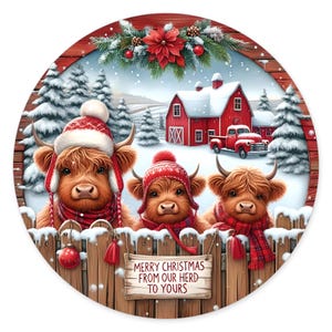 May include: A round decorative sign featuring three Highland cows wearing winter hats and scarves behind a wooden fence. The scene includes a red barn, a red truck, and snow-covered pine trees. A sign on the fence reads, Merry Christmas from our herd to yours.