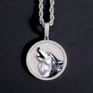 May include: A silver chain necklace with a round pendant featuring a detailed wolf head design. The pendant is encrusted with clear cubic zirconia stones.