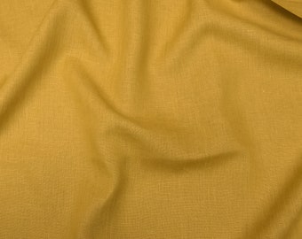 May include: A close-up of a crumpled piece of fabric in a mustard yellow color. The fabric has a linen texture.