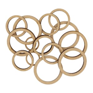 May include: A set of wooden circles of various sizes, arranged in a random pattern. The circles are all made of natural wood and have a light brown colour.