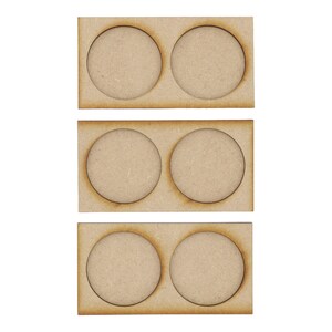 May include: Three wooden paint pot holders with two circular cutouts in each. The holders are stacked on top of each other.