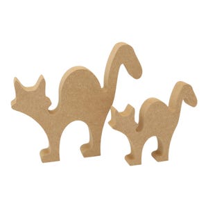 May include: Two wooden cat cutouts in varying sizes. The cats are light brown and have a simple, stylized design. The cats are standing upright with their tails curved. The background is plain white.