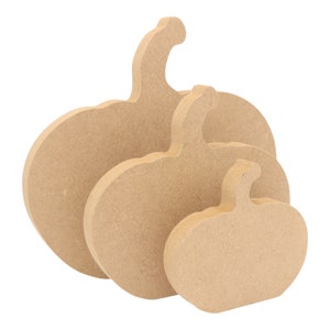 May include: Three unfinished wooden pumpkins of varying sizes, stacked on top of each other. The pumpkins are all in the shape of a traditional pumpkin with a stem.
