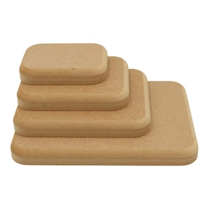 May include: Four light brown cork squares of different sizes are stacked. Each square has rounded edges and a textured surface. The largest square is at the base, with the others decreasing in size. The cork has a natural appearance.