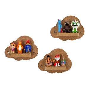 May include: Three wooden cloud-shaped shelves with a brown finish. Each shelf has a different set of cartoon character figurines. The top shelf has a blue character, a brown character, and a green character. The middle shelf has a pink character, an orange character, and a blue character. The bottom shelf has a brown character, a red character, and a white character.