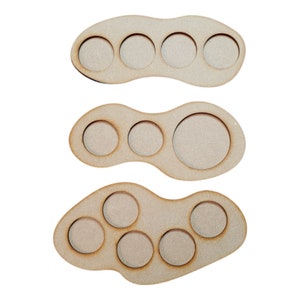May include: Three wooden trays with circular cutouts for holding miniature figures. The trays are shaped like irregular ovals and have a natural wood finish.