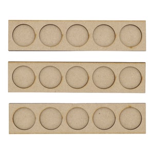 May include: Three wooden paint pot holders with six circular cutouts in each. The holders are stacked on top of each other.