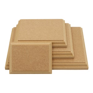 May include: A set of five unfinished wooden plaques, stacked in a pyramid shape. The plaques are all rectangular and have a smooth, natural wood finish.