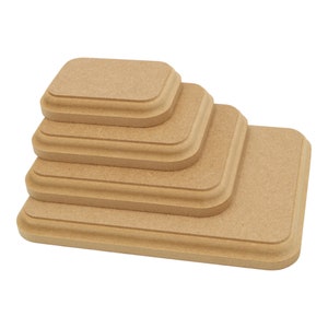 May include: Set of five rectangular wooden display risers, stacked in a pyramid shape. The risers are made of natural wood with a light brown colour and have a slightly rounded edge.