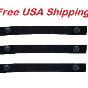 May include: Three black elastic straps with black buttons on each end. The straps are approximately 1 inch wide.