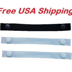 May include: Three fabric straps with adjustable buttons. One strap is black, and the other two are white.