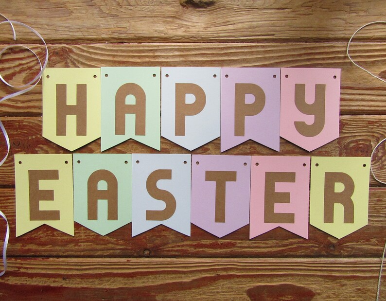 Pode incluir: Uma faixa de cores pastel com as palavras "Happy Easter" em letras marrons. A faixa &eacute; feita de papel e tem uma borda festonada.
