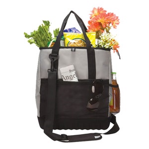 Może przedstawiać: Szara i czarna izolowana torba na zakupy z kieszenią zapinaną na zamek błyskawiczny, kieszenią siatkową i paskiem na ramię. Torba jest wypełniona produktami spożywczymi, kwiatami i gazetą.