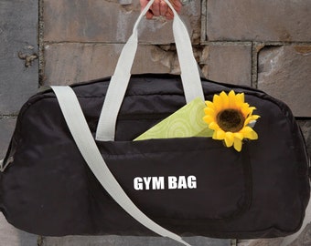 May include: A black gym bag with white straps and a white zipper. The bag has a small pocket on the front with a sunflower and a green object inside. The bag has the text "GYM BAG" printed on the front.