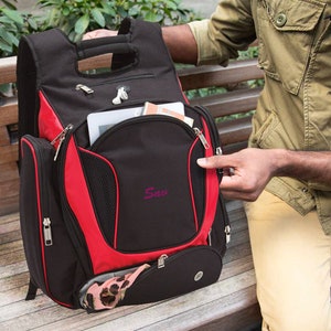 May include: A black and red backpack with a zippered pocket and a mesh pocket. The backpack has a handle on the top and a logo that says "Saw" on the front.