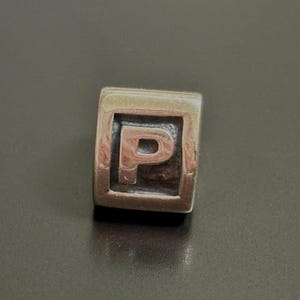 Charm original con inicial P de PANDORA 790323P en plata de ley, nuevo y RETIRADO. Viene con bolsa de regalo PANDORA. Envío rápido.
