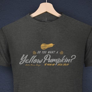 Könnte beinhalten: Ein dunkel-melierter grauer T-Shirt mit einer gelben Kürbisgrafik und dem Text "Do you want a Yellow Pumpkin?  Je VOM AD I ZOCA ZALAT!" in weißer Schrift. Der Text "ANTICA FOR NACE DESIGN" ist in weißer Schrift auf schwarzem Hintergrund am unteren Rand des Bildes.