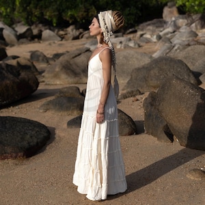 Savita is the ultimate raw cotton bridal gown for free-spirited celebrations by the sea. With its plunging V neckline, stretchy smocked back, and tiered maxi skirt, this beach wedding dress flatters every figure while offering breezy movement and timeless bohemian charm. Whether you’re planning a sand-side elopement or a sacred desert ceremony, this handmade, unlined dress brings softness, breathability, and sustainable style to your special day.
