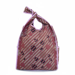 Studio image of the Kaia Dusty Rose Polka Kantha hobo bag showcasing the diagonal stripe and polka pattern, wide shoulder strap, and reversible vintage quilt cotton construction. One-of-a-kind artisan tote made from reclaimed textiles.