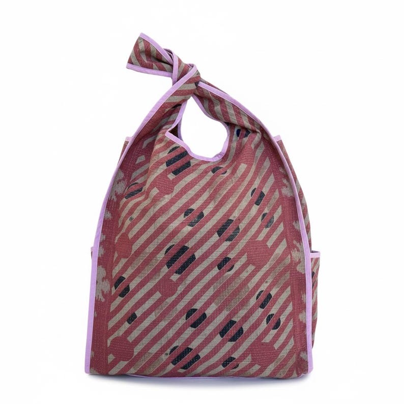 Studio image of the Kaia Dusty Rose Polka Kantha hobo bag showcasing the diagonal stripe and polka pattern, wide shoulder strap, and reversible vintage quilt cotton construction. One-of-a-kind artisan tote made from reclaimed textiles.
