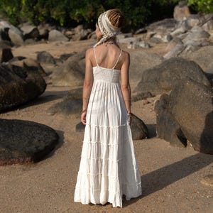 Designed for boho brides and nature-loving souls, the Savita Dress in raw cotton radiates ease and elegance. Ethically made and ultra-lightweight, it features a softly tiered skirt, adjustable straps, and a smocked waist for flexible sizing. Its creamy, unlined fabric makes it ideal for beach weddings, maternity shoots, and intimate rituals. This cotton maxi dress is a soulful, versatile addition to any warm-weather bridal wardrobe or conscious capsule collection.