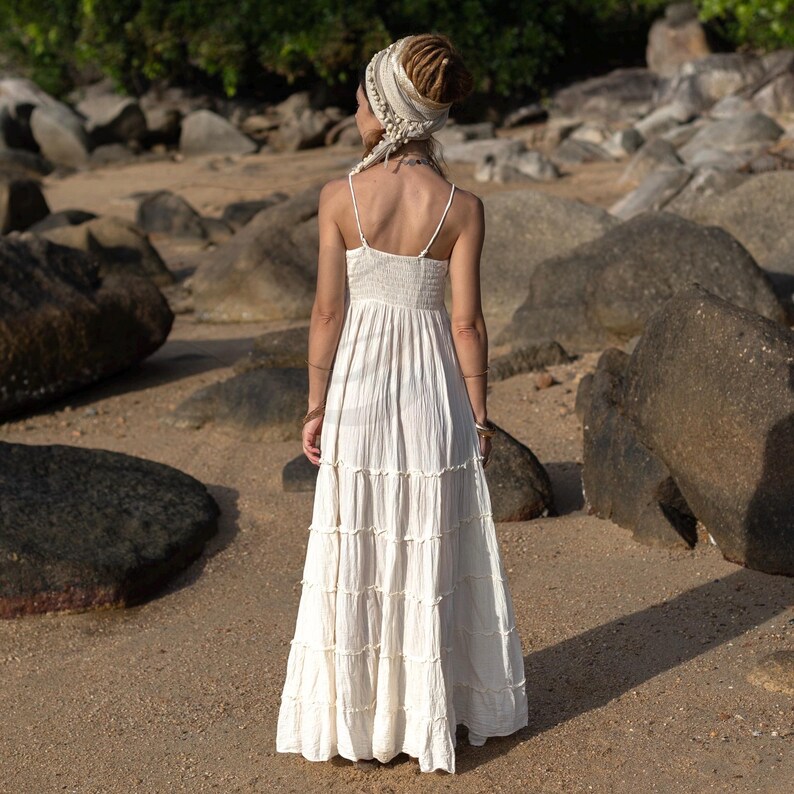 Designed for boho brides and nature-loving souls, the Savita Dress in raw cotton radiates ease and elegance. Ethically made and ultra-lightweight, it features a softly tiered skirt, adjustable straps, and a smocked waist for flexible sizing. Its creamy, unlined fabric makes it ideal for beach weddings, maternity shoots, and intimate rituals. This cotton maxi dress is a soulful, versatile addition to any warm-weather bridal wardrobe or conscious capsule collection.