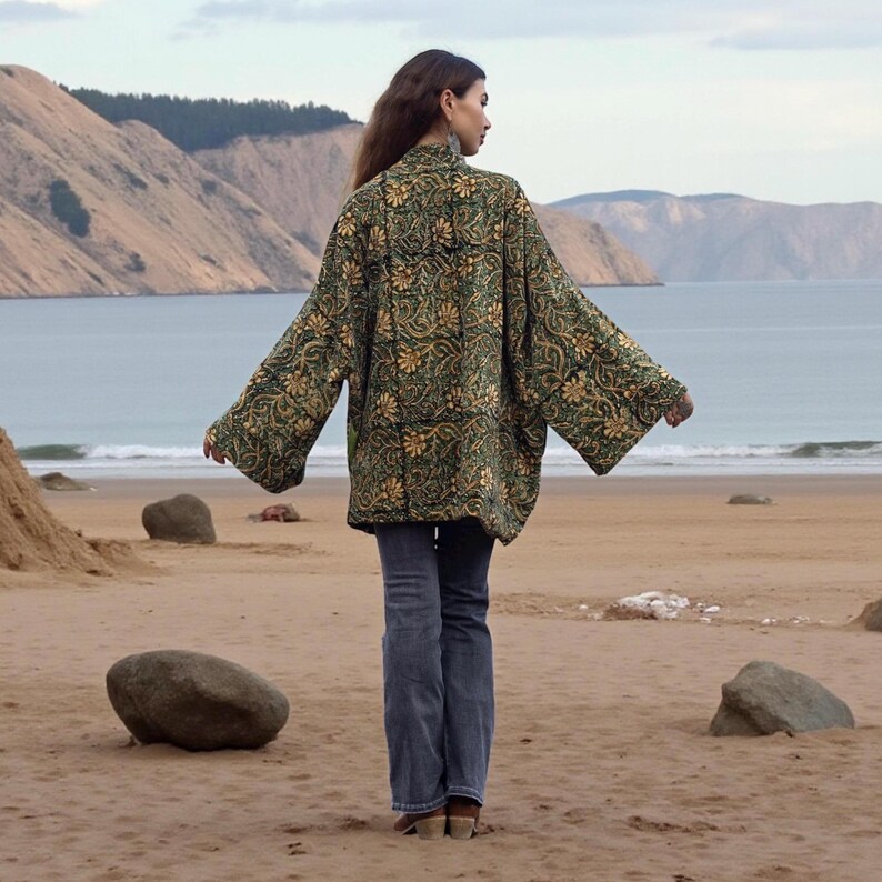 Back view of oversized quilted kimono jacket in moss green and ochre paisley print, featuring wide bell sleeves and flowing silhouette — ZinniaPearl bohemian jacket.