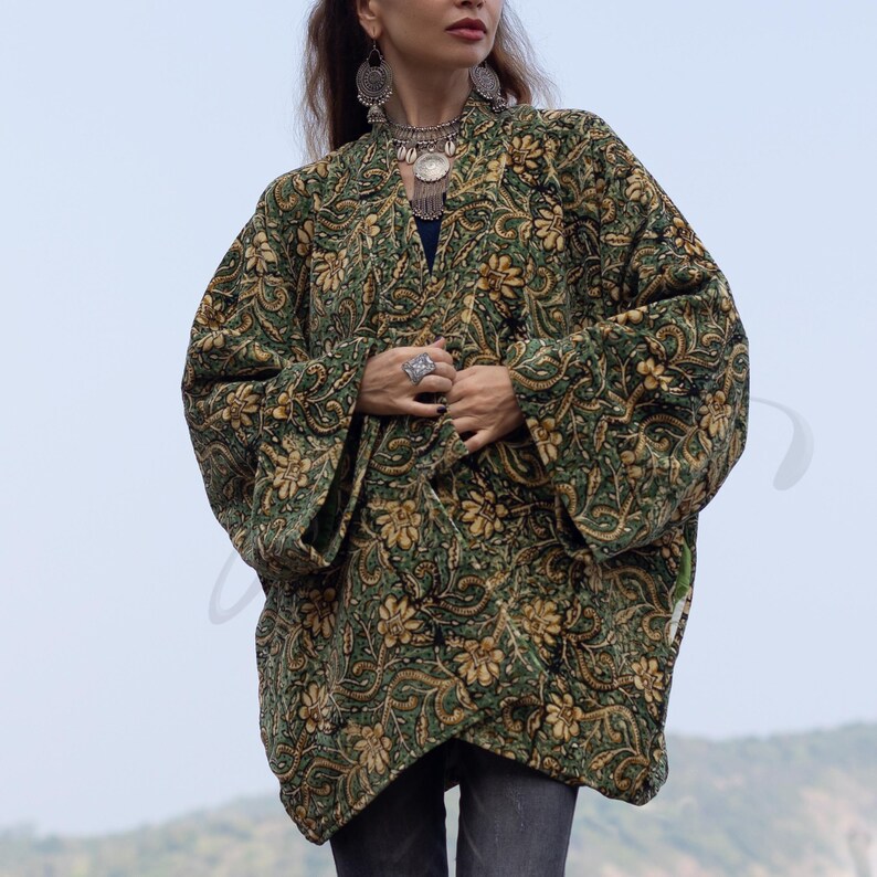Close-up of emerald and gold floral velvet kimono jacket showcasing intricate block printing, plush velvet texture, and artisan detail. Styled with layered silver jewelry, it reflects ZinniaPearl’s handmade bohemian luxury.