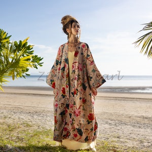 May include: A beige floral print kimono with red and blue accents, worn over a yellow dress. The open-front design is visible. The background shows a beach and ocean. The text "Z pearl" is visible on the kimono.