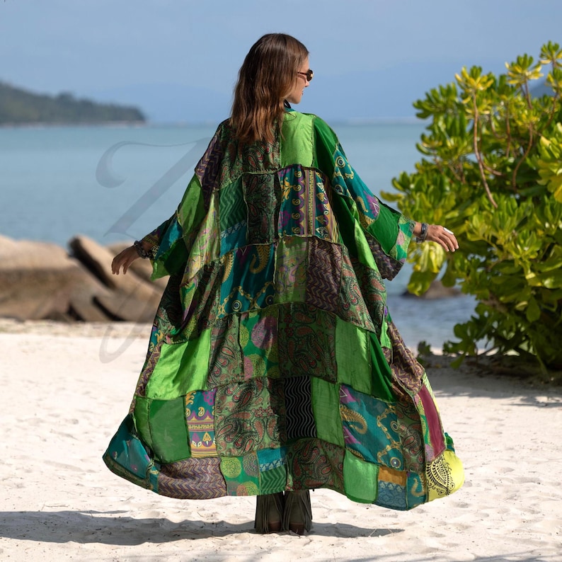 Back view of the Harper Jade Vintage Silk Kimono in Emerald Oasis colorway, highlighting the intricate patchwork of emerald, teal, and patterned silk squares. The robe’s flowing silhouette and wide sleeves create effortless movement, perfect for goddess-inspired styling at the beach, resort, or music festivals. A handmade, eco-conscious bohemian duster.