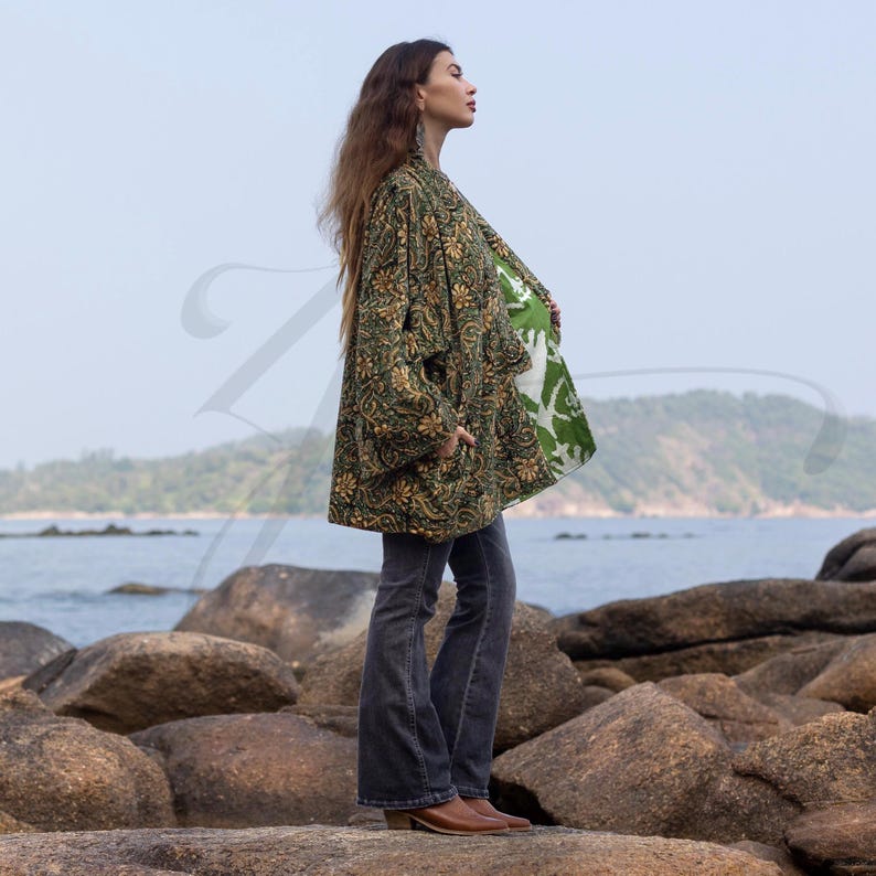 Profile view of model in emerald green velvet kimono jacket showing contrasting hand block-printed cotton lining in light green and white. The flowy duster moves with coastal wind, blending bohemian artistry and natural elegance.