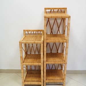 May include: Two wicker shelves, one taller than the other, with a woven design. The shelves are made of natural brown wicker and have four shelves each.
